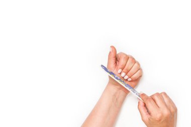 Kadın tırnaklarını kopyalama alanı olan beyaz bir arkaplan üzerine renkli bir dosya ile dolduruyor