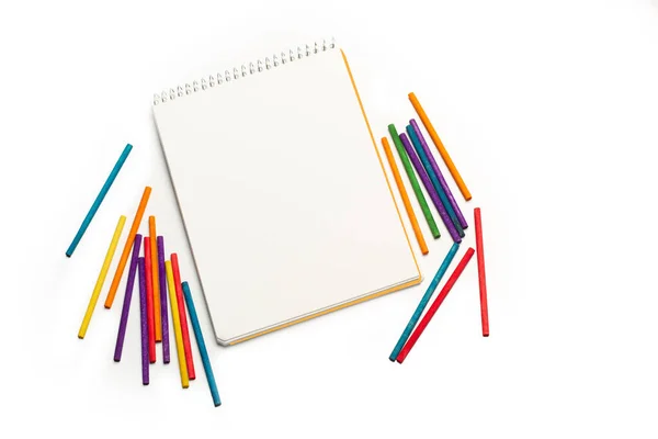 コピースペースのある白い背景にカラーのチョークと空白のノートパッド — ストック写真