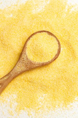 Tahta bir kaşıkta mısır unu ve beyaz bir arka planda üst bir manzarada