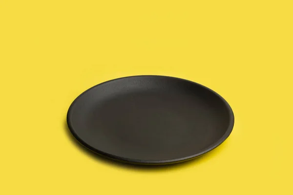 Μαύρο Στρογγυλό Πιάτο Κίτρινο Φόντο Χώρο Αντιγραφής — Φωτογραφία Αρχείου