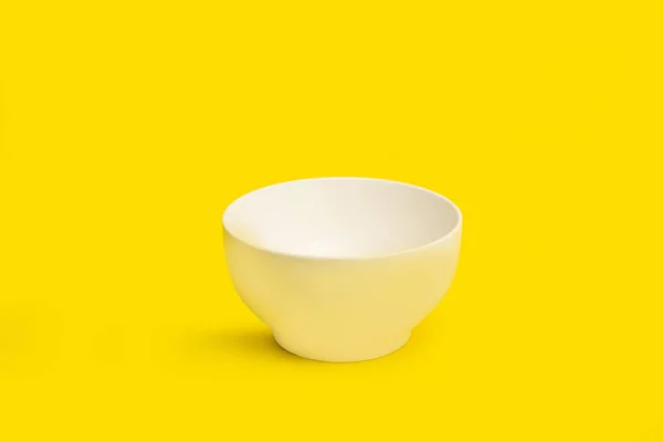 带有复制空间的黄色背景的黑色陶瓷碗 — 图库照片