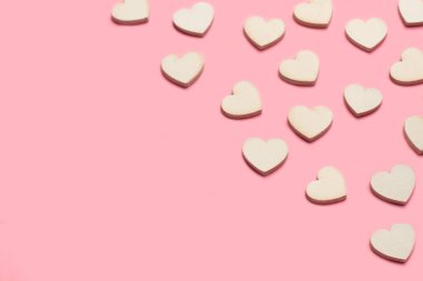 Pembe arka planda, kopyalama alanı olan beyaz tahta kalpler.