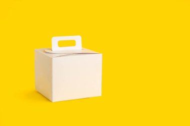 Fotokopi alanı olan sarı bir zemin üzerinde beyaz bir karton kutu