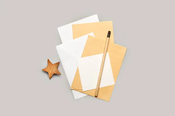 白と茶色の封筒 鉛筆とトップビューの灰色の背景に木星 — ストック写真