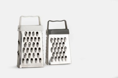 İki paslanmaz çelik rendeleyici beyaz bir arkaplanda fotokopi alanı ile