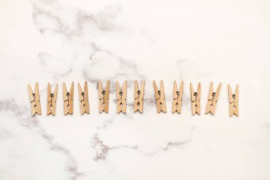 Gri ve beyaz mermer mutfak tezgahında küçük ahşap mandallar.