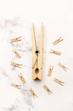 Gri ve beyaz mermer mutfak tezgahında büyük ve küçük ahşap mandallar.