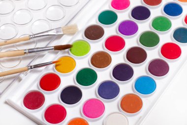 Resimler ve suluboya resimler beyaz bir arkaplanda üstten görünüyor.