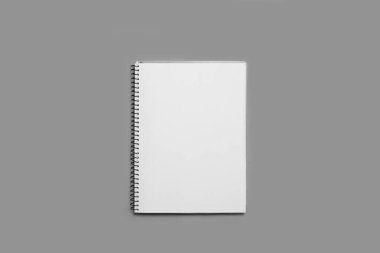 Gri arkaplan üzerinde boş beyaz bir sayfa üzerinde kopyalama alanı olan açık bir defter