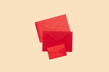 Bej arkaplanda üç kırmızı zarf ve kopyalama alanı