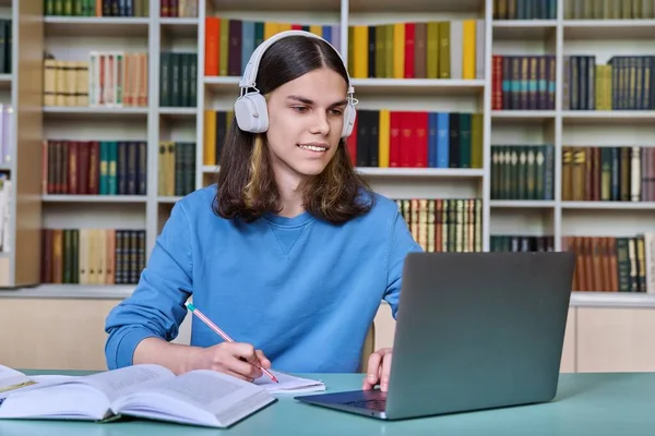 Dospívající Student Studující Knihovně Chlápek Sluchátkách Používá Notebook Dívá Obrazovku — Stock fotografie
