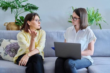 Terapi seansı, psikolog muayenehanesinde danışmanlık yapan olgun bir kadın not alan genç bir kadın terapist. Psikoloji, psikoterapi, profesyonel yardım, 40 'lı yaşlarda orta yaşlı insanların akıl sağlığı.