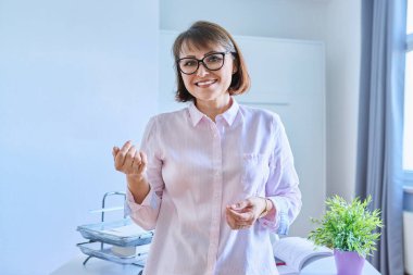 Ofisteki masanın yanında kendine güvenen orta yaşlı bir kadının portresi. Kameraya bakan 40 'lı yılların pozitif iş kadını yönetici öğretmen akıl hocası. Uzaktan çalışma serbest kariyer personeli