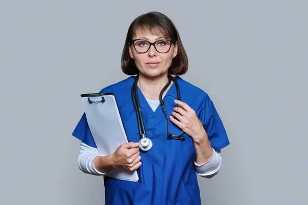 Portrait Female Doctor Clipboard Looking Camera Grey Studio Background Middle — Stock Photo, Image