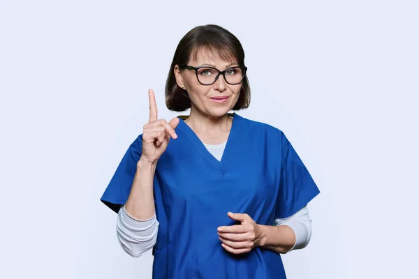 女护士竖起大拇指 注意手势符号 在白色工作室背景上 — 图库照片