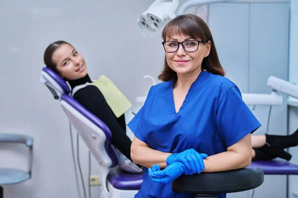 Porträtt Leende Kvinnlig Tandläkare Tittar Kameran Med Ung Tonåring Flicka — Stockfoto