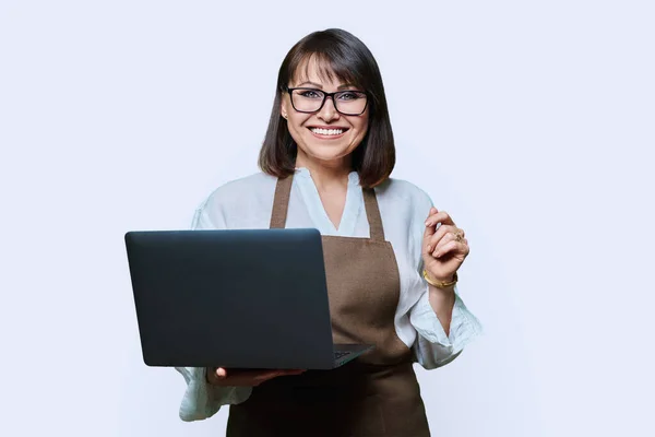 Portrait Middle Aged Woman Apron Laptop White Studio Background Smiling — Stock Photo, Image