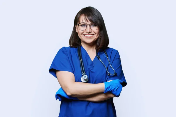 带听诊器的护士医生妇女的肖像 在白色工作室背景下看着相机 穿着蓝色制服的积极友善的医务工作者 工作人员 保健概念 — 图库照片
