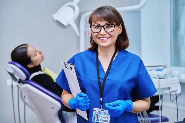 Portret Uśmiechniętej Dentystki Patrzącej Kamerę Młodą Pacjentką Siedzącą Krześle Dentystycznym — Zdjęcie stockowe