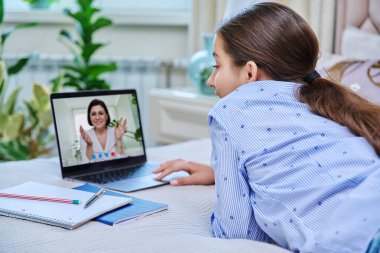 Video konferansı, genç kız öğrencinin bilgisayar ekranında öğretmenle konuşması. Evdeki webcam 'e bakan bir genç, uzak online ders mesafesi öğrenme kursu. E-eğitim teknolojisi lise