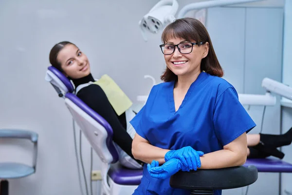Dişçi Koltuğunda Oturan Genç Kız Hastayla Kameraya Bakan Gülümseyen Kadın — Stok fotoğraf