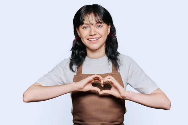 Χαμογελαστή Νεαρή Υπηρέτρια Ποδιά Που Δείχνει Χειρονομία Καρδιάς Χέρια Λευκό — Φωτογραφία Αρχείου