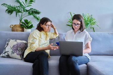 Bireysel terapide orta yaşlı bir kadın, kadın psikolog ve hasta ofiste koltukta yan yana oturuyor. Psikoloji, danışmanlık, psikoterapi, akıl sağlığı, sağlık hizmetleri, olgun insanlar konsepti