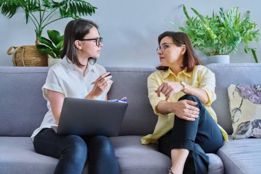 Bireysel terapide orta yaşlı bir kadın, kadın psikolog ve hasta ofiste koltukta yan yana oturuyor. Psikoloji, danışmanlık, psikoterapi, akıl sağlığı, sağlık hizmetleri, olgun insanlar konsepti
