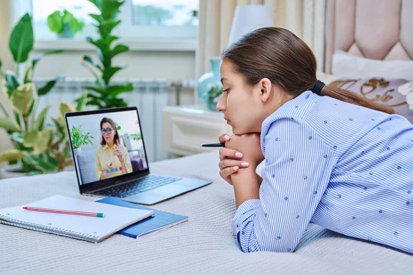 Video conference, teen girl student talking to teacher on laptop screen. Teenager looking at webcam at home, remote online lesson distance learning course. E-education technology high school