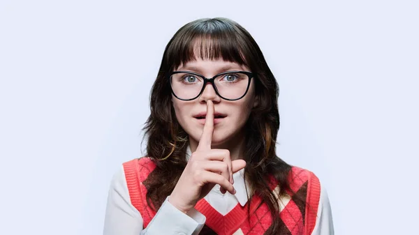 眼镜上的年轻情色女性展示符号符号秘密嘘 食指唇 光工作室背景 神秘沉默的概念 — 图库照片