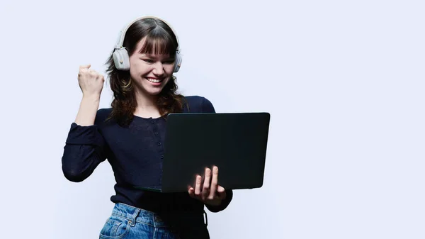 Happy Young Female Headphones Looking Laptop Screen Rejoicing Showing Hand — 图库照片