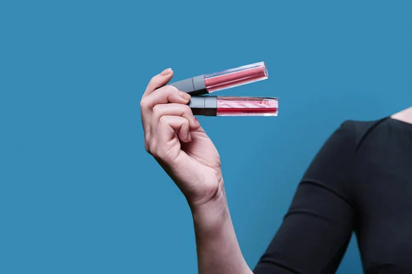 Close Two Trendy Lip Glosses Hand Blue Studio Background Cosmetic —  Fotos de Stock