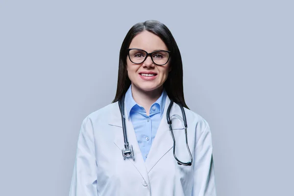 身穿白衣的女医生的画像 在浅灰工作室背景下看着相机 医务人员 科学医学概念 — 图库照片