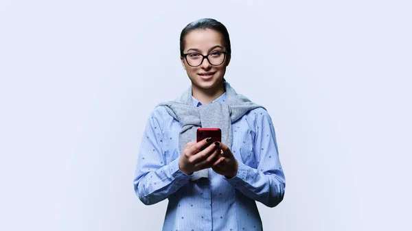 Young Attractive Smiling Female Smartphone Hands Looking Camera White Studio — Foto de Stock