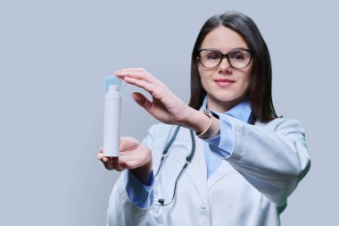 Eczane dermatokozmetiği, doktor dermatolog gri arka planda normal kuru yağlı yüz derisi için boş beyaz tüp kremi emülsiyonu öneriyor. Temizleyici, nemlendirici, besleyici, cilt