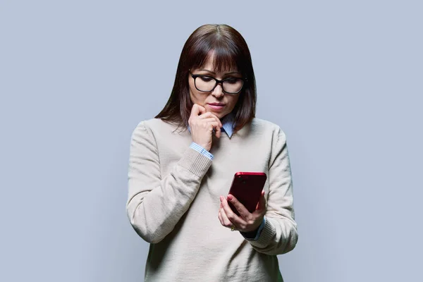 Бажана Жінка Середнього Віку Читає Смартфоні Сірий Студійний Фон Мобільний — стокове фото