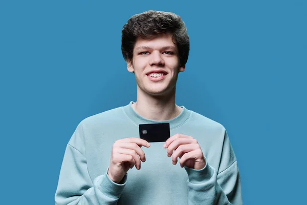 Junger Gutaussehender Kerl Mit Kreditkarte Der Hand Auf Blauem Studiohintergrund — Stockfoto