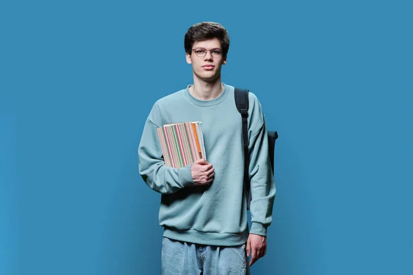 Egy Fiatal Jóképű Férfi Egyetemista Portréja Szemüvegben Hátizsákkal Jegyzetfüzetekkel Kék — Stock Fotó