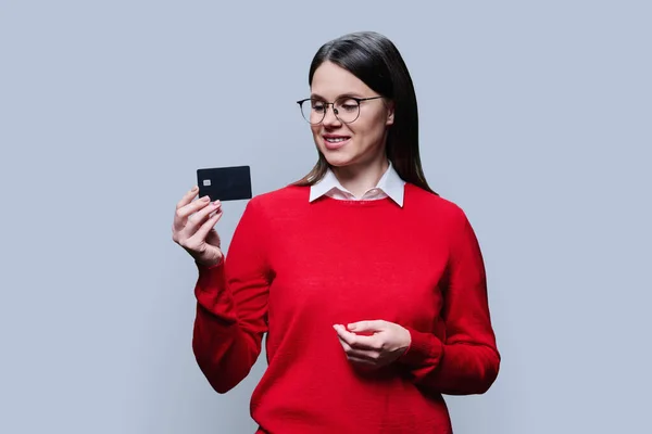 Mujer Joven Rojo Mostrando Tarjeta Crédito Bancaria Sobre Fondo Estudio — Foto de Stock