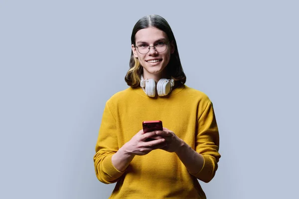 Joven Macho Inteligente Con Smartphone Mirando Cámara Sobre Fondo Color — Foto de Stock