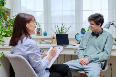 Kadın sosyal hizmet görevlisi, psikolog, akıl hocası mülakat, ofiste genç bir erkekle konuşma. Profesyonel yardım, danışmanlık, psikoloji, danışmanlık, danışmanlık, gençlik eğitimi kavramı