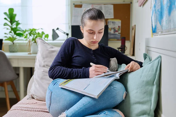 Adolescente Estudiando Casa Leyendo Libros Texto Escribiendo Cuaderno Sentada Sofá —  Fotos de Stock