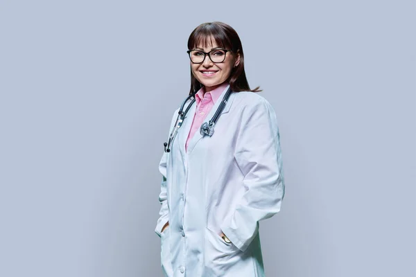 有信心的成熟女医生的画像 白色外套 灰色背景 在镜头前微笑的中年女性 职业医学 职业科学 健康保护 — 图库照片