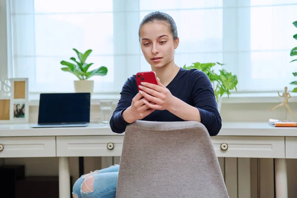 Teenagermädchen Mit Smartphone Der Hand Auf Einem Stuhl Heimischen Zimmerinneren — Stockfoto