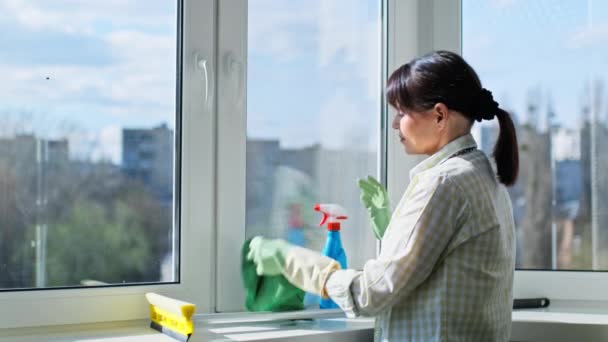 Γυναίκα Καθαρισμού Παράθυρα Στο Σπίτι Χρησιμοποιώντας Σπρέι Και Ύφασμα Μικροϊνών — Αρχείο Βίντεο