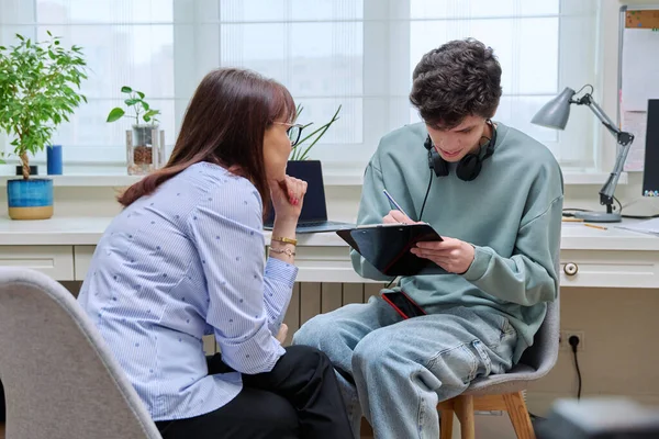 stock image Woman social worker, psychologist, mentor interviewing, talking to young male in office. Professional help, consultation, psychology, mentoring, counseling, training youth concept