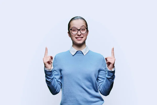 十几岁的女孩用手指指向空旷的文字空间 白色的工作室背景 青少年 高中生 为儿童和青少年展示商品和服务的广告 — 图库照片