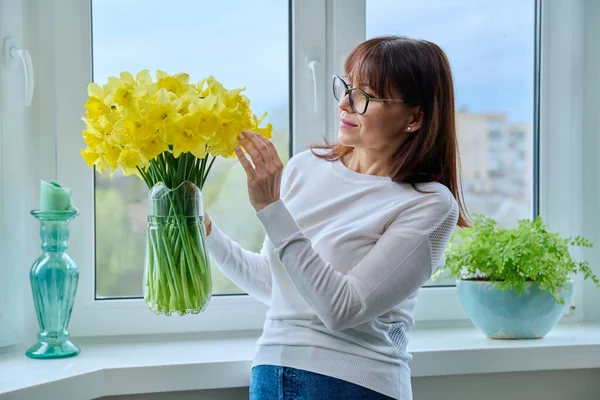 Reife Frau Mit Einem Blumenstrauß Einem Krug Hause Fenster Frühling — Stockfoto