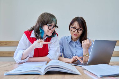 Genç bayan öğretmenle birlikte yabancı diller öğreniyor. Özel öğretmen ve öğrenci ofiste oturuyor, kitaplar, defterler, dizüstü bilgisayarlar kullanıyor. Eğitim, bilgi, öğrenme kavramı