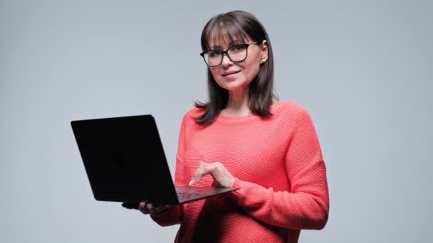 Lächelnde Frau Mittleren Alters Mit Laptop Der Hand Auf Grauem — Stockvideo